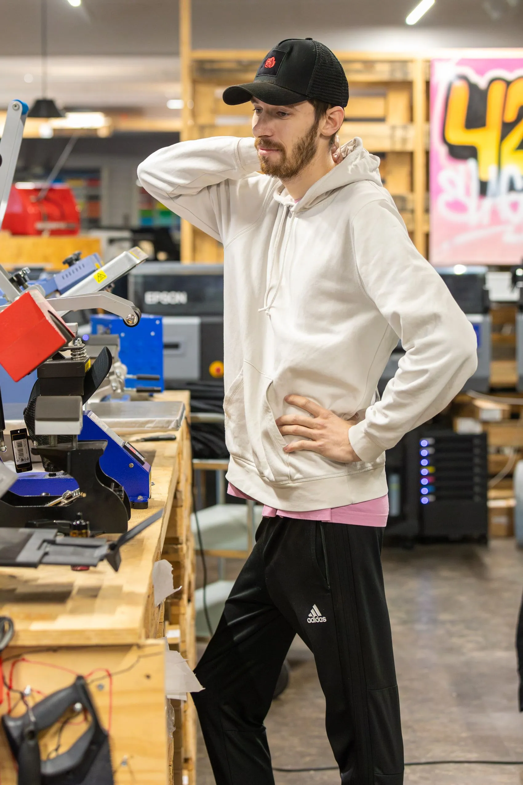 En medarbejder står ved pressemaskinerne på AS Merch’ værkstedsgulv.